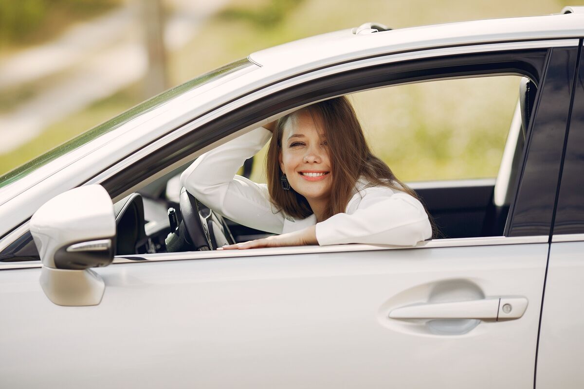 Condutora sorridente ao volante do seu carro